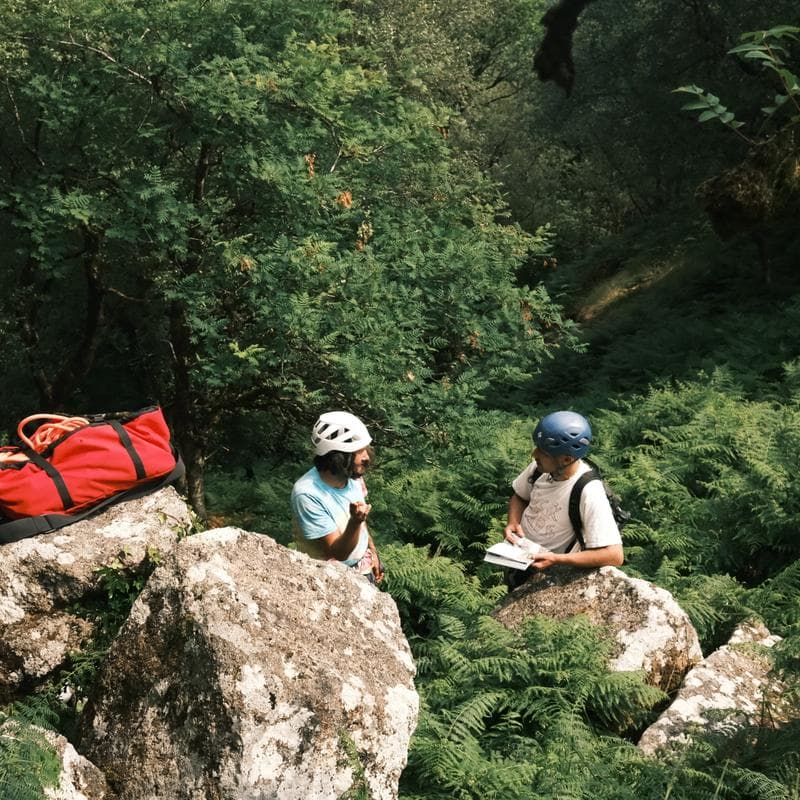 Two people in a forest with their climbing equipment. 